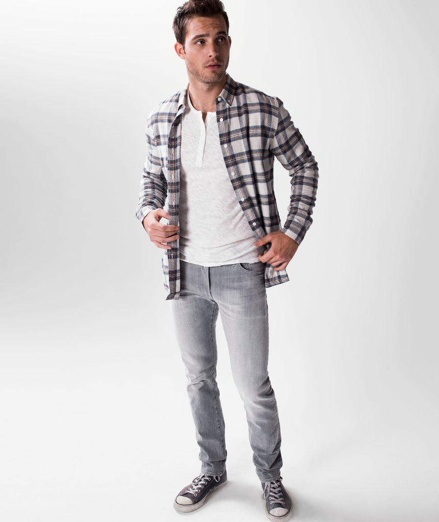 Model wearing S.M.N Studio's Hunter in Owen Men's Jeans with a casual outfit completed by a flannel and henley shirt underneath