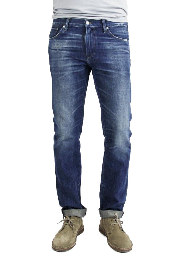 S.M.N Studio's Hunter in Rainer Men's Jeans - 100% Cotton Selvedge Slim fit jean made in a dark indigo wash contrasted with light fades, honeycombs, whiskers, and slight tear details 