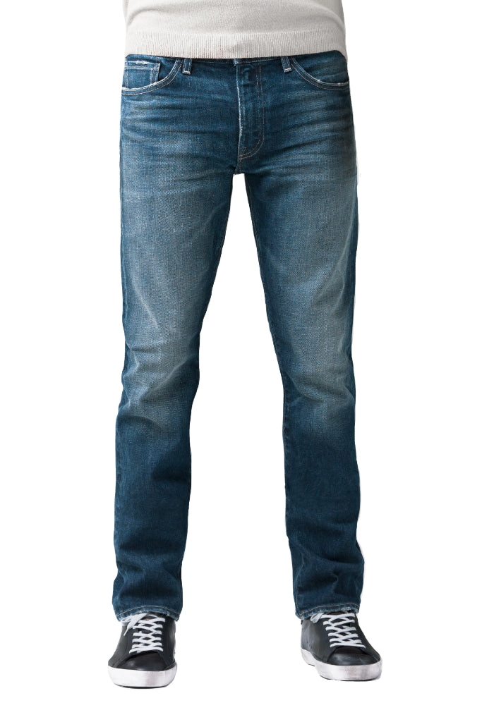 S.M.N Studio's Bond in Sundance Men's Jeans. A slim straight darker blue wash jean accented with contrasting fades and whiskers for a worn in look. It's made in a comfort stretch Japanese denim. 