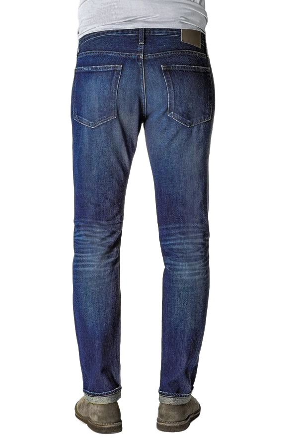 Back of S.M.N Studio's Hunter in Rainer Men's Jeans - 100% Cotton Selvedge Slim fit jean made in a dark indigo wash contrasted with light fades, honeycombs, whiskers, and slight tear details 