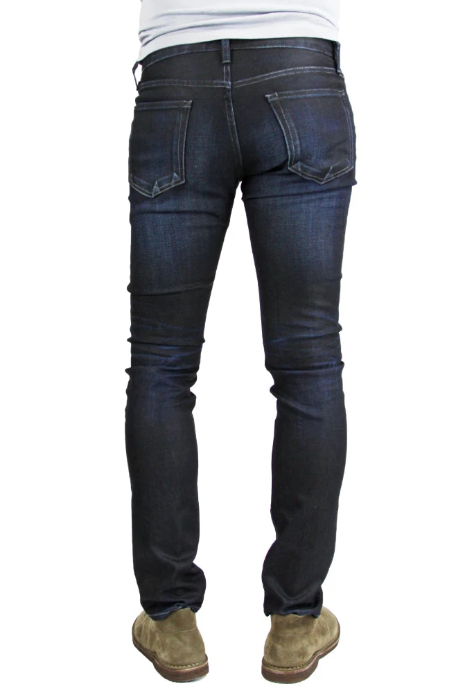 Back of S.M.N Studio's Hunter in Empire Men's Jeans - Slim fit jeans made up in a premium comfort stretch denim with a dark indigo wash characterized by light contrast fades, accented 3D whiskers, and honeycombs