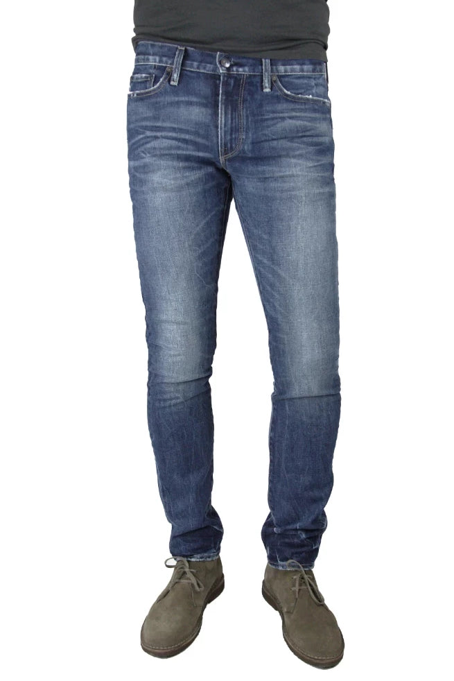 S.M.N Studio's Finn in Diver Men's Jeans. A tapered slim fit medium wash jean in comfort stretch premium Japanese denim. The wash is contrasted with 3D whiskers and fading for a naturally vintage look.
